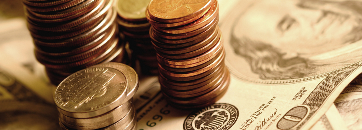 Stacks of coins atop a $100 bill