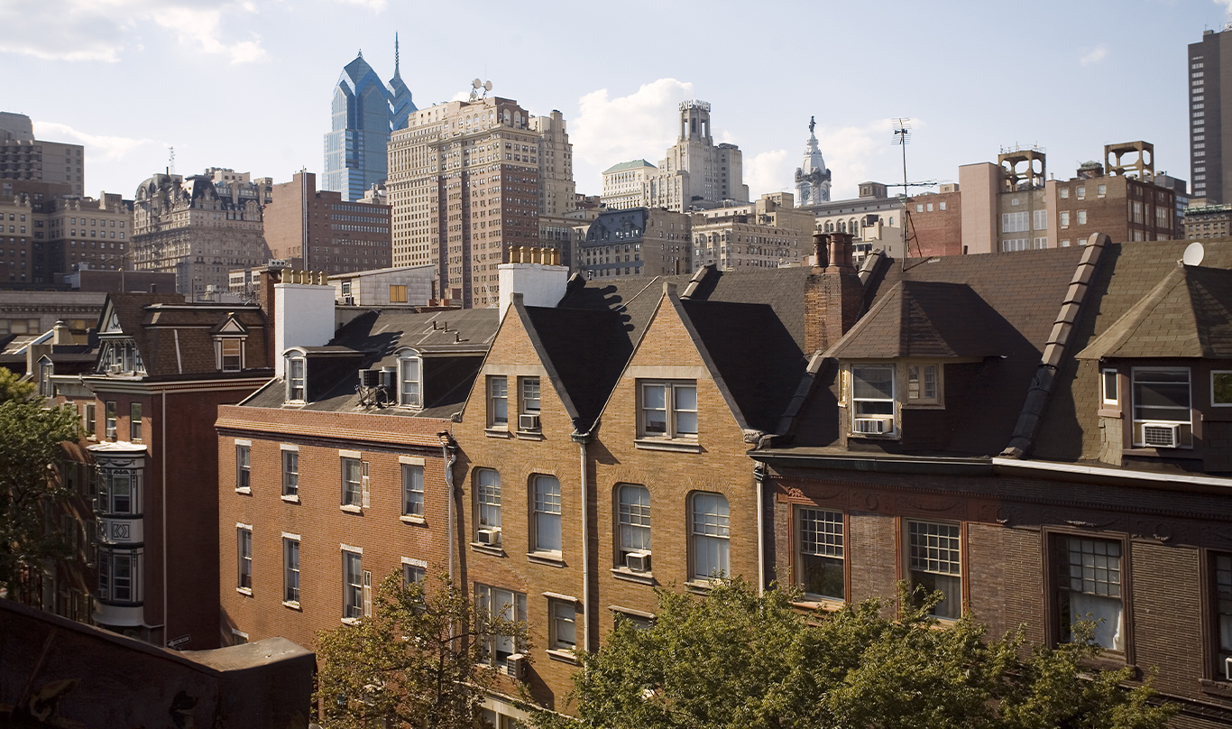 Row homes with the skyline of Philadelphia in the background.