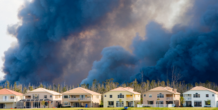 A forest fire burns just beyond a neighborhood.