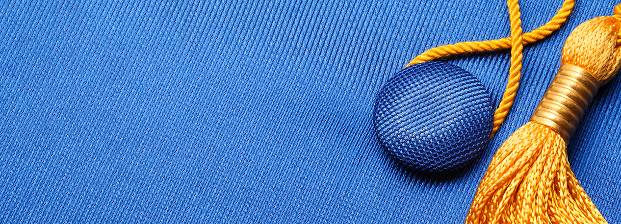 Close-up of a royal blue mortarboard cap with gold tassel