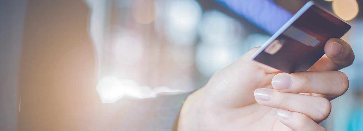 Individual holding a credit card in one hand