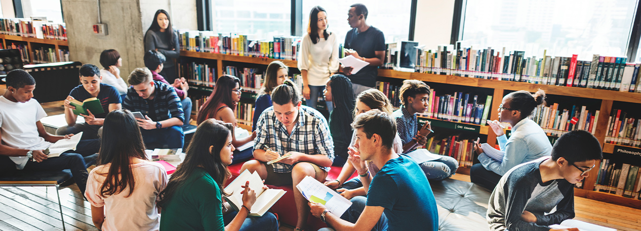 In a library, students engage in group discussion.