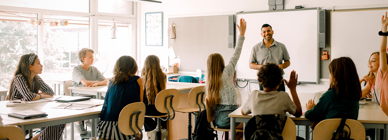 Enthusiastic students raise their hands during a lesson.