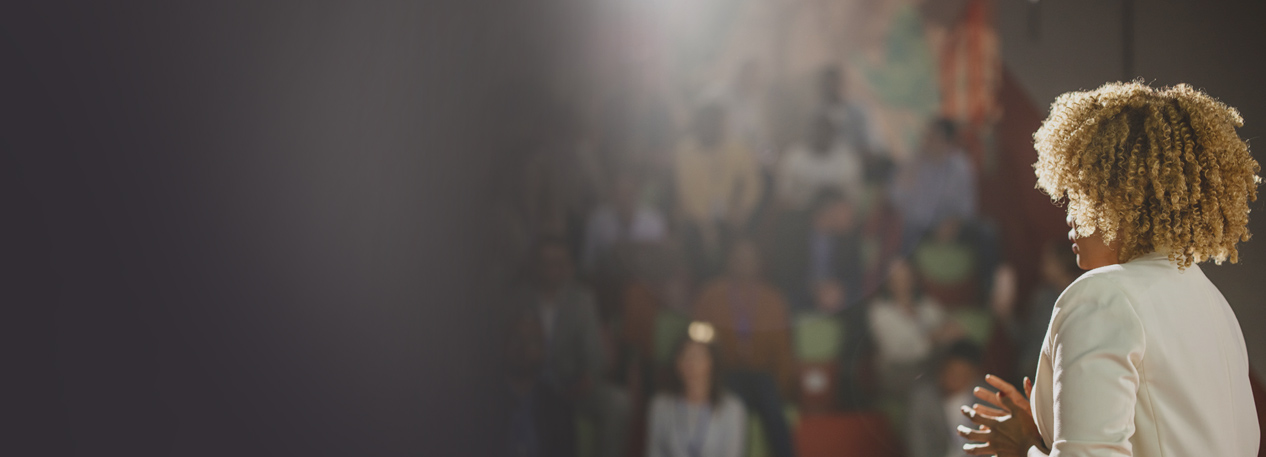 Woman standing in front of an audience.