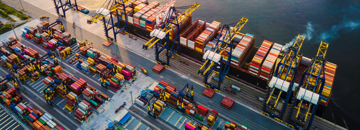 A busy port with cranes and shipping containers.