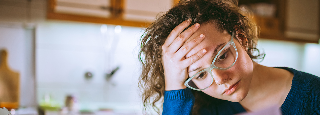 Woman looking at a form and appearing to be worried or stressed.