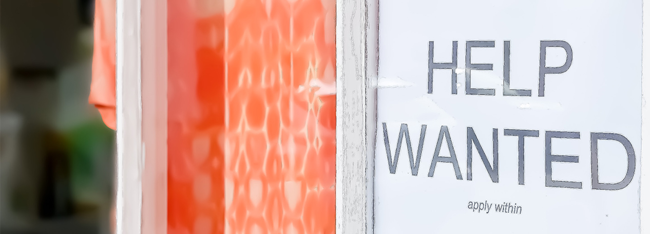 "Help Wanted" sign in a store window.