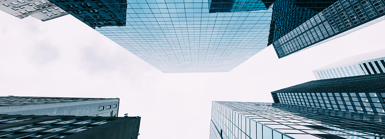 Looking up at the sky in a city, surrounded by skyscraper buildings