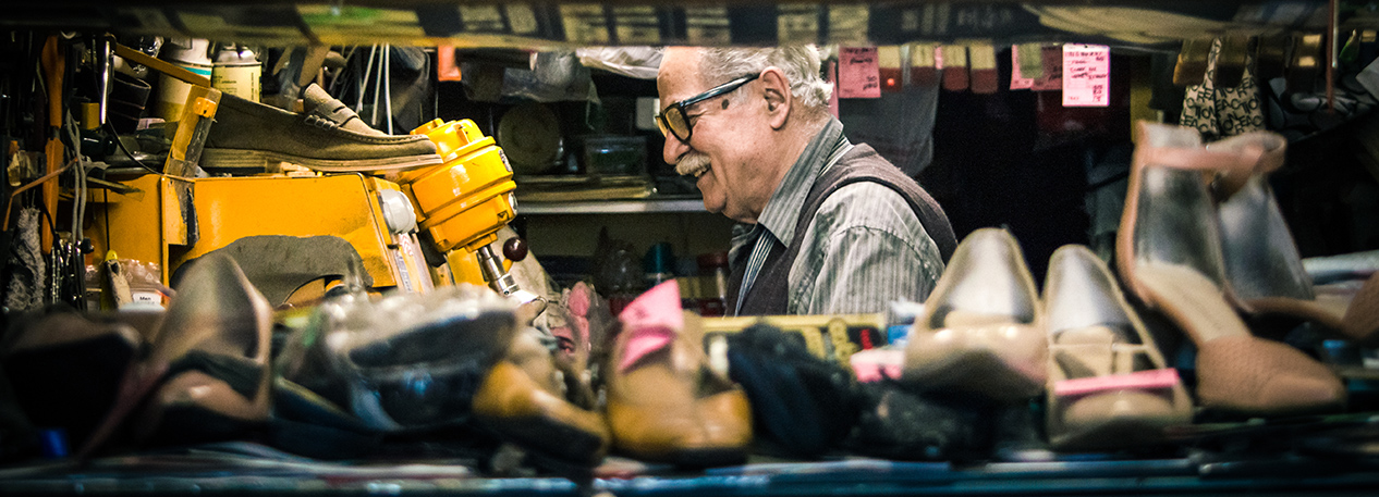 Older man with glasses working in a shoe repair shop