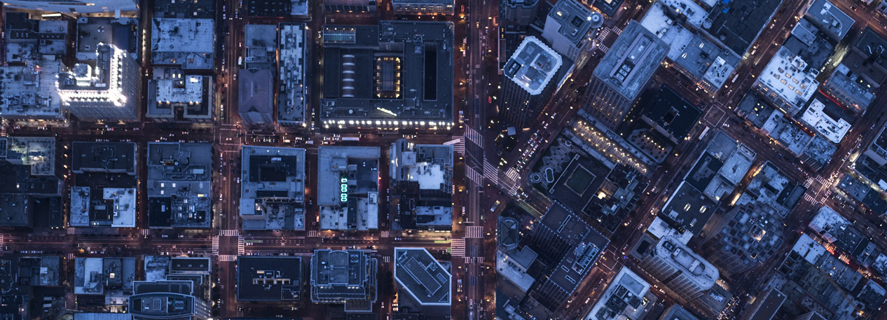 A bird's-eye view of city buildings at night.