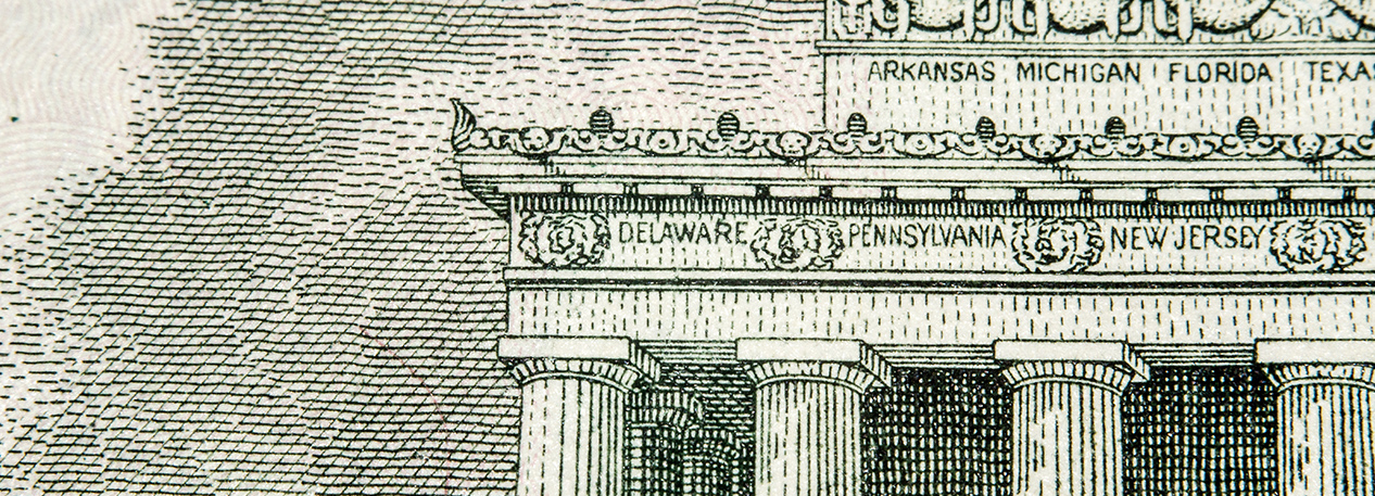 Close-up of the Lincoln Memorial on the five-dollar bill with the inscriptions for "Delaware," "Pennsylvania," and "New Jersey" visible