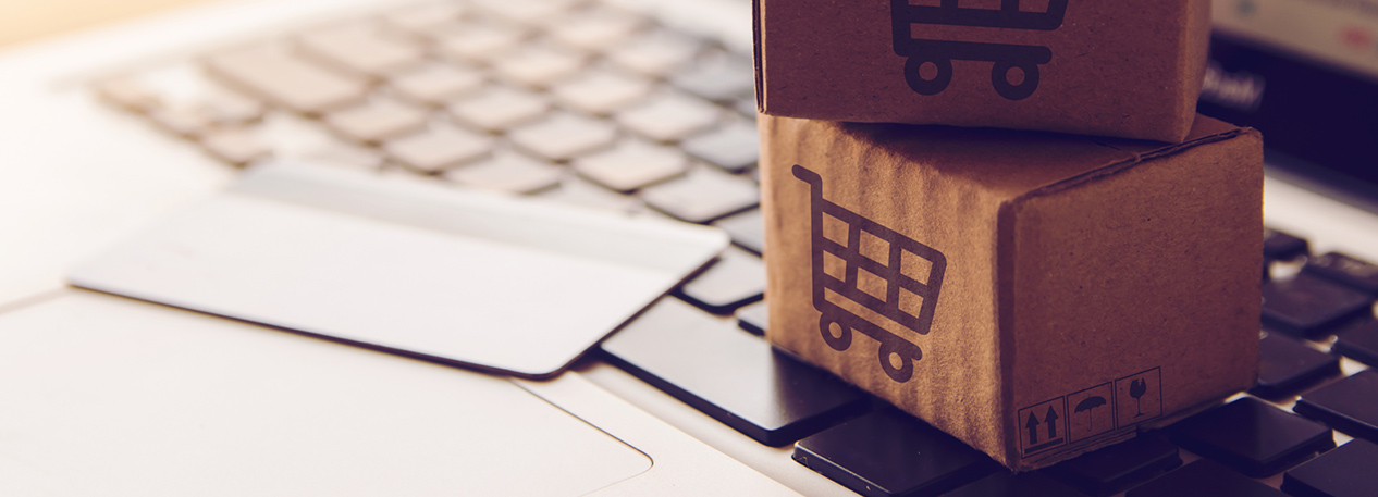 Small delivery boxes and a credit card sitting on a laptop computer