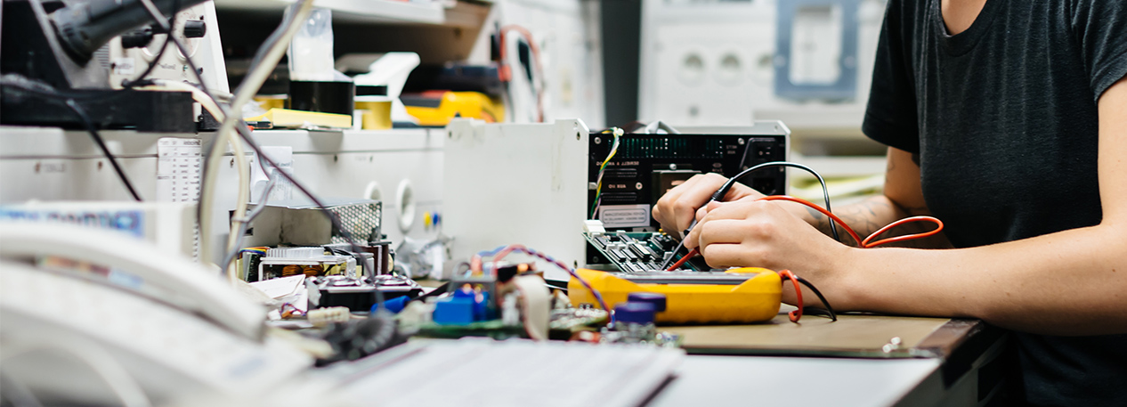 Female engineer working with electronic equipment at a workbench