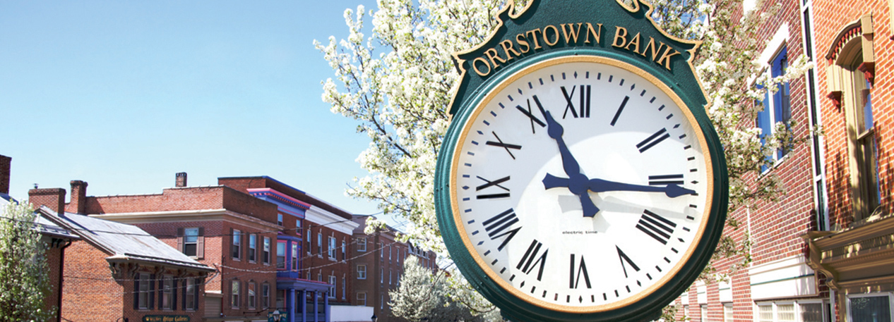 Small-town main street with a clock labeled "Orrstown Bank."