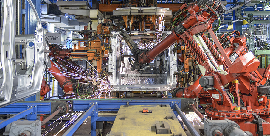 Robot welders working on an assembly line.