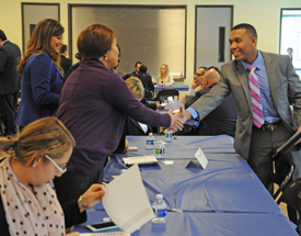 A graduate of the BankWork$ program in Los Angeles meets a bank recruiter at a job fair after a graduation ceremony.