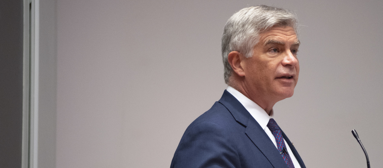 Side view of Philadelphia Fed Presiden Harker speaking at a podium