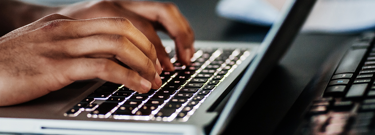 Individual typing on a laptop keyboard