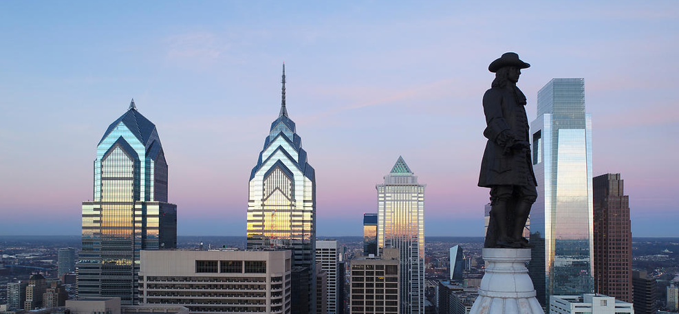 Philadelphia skyline with a closeup of William Penn statue and skyscrapers in the background